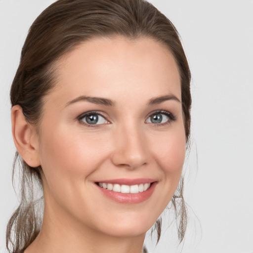 Joyful white young-adult female with medium  brown hair and grey eyes