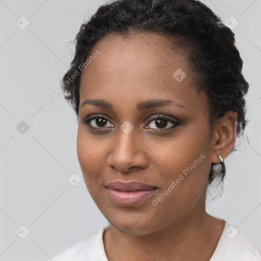 Joyful black young-adult female with short  black hair and brown eyes