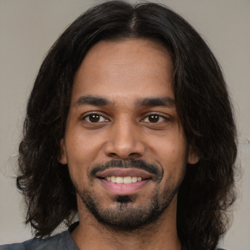 Joyful black young-adult male with medium  black hair and brown eyes
