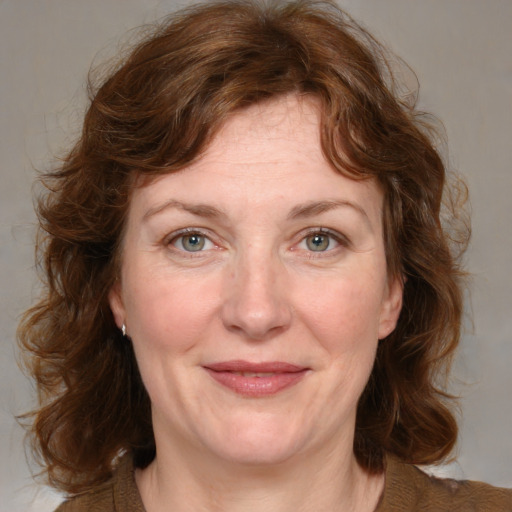 Joyful white adult female with medium  brown hair and blue eyes