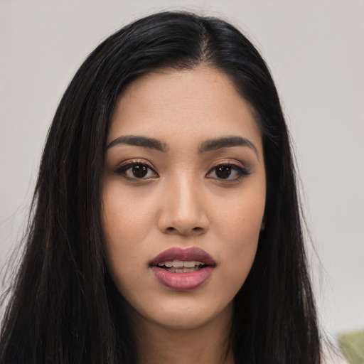 Joyful asian young-adult female with long  black hair and brown eyes