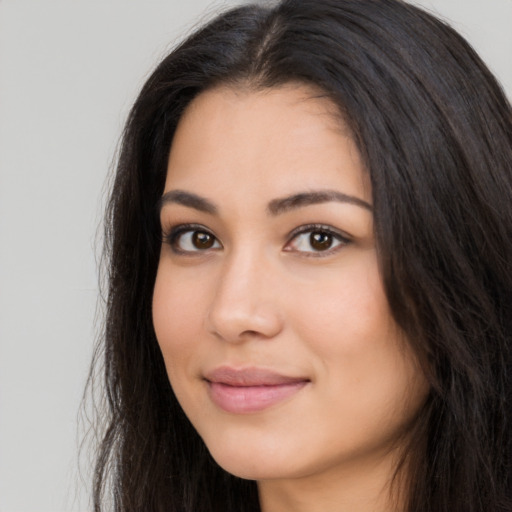 Joyful latino young-adult female with long  brown hair and brown eyes