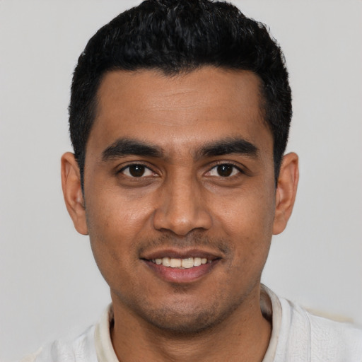 Joyful latino young-adult male with short  black hair and brown eyes