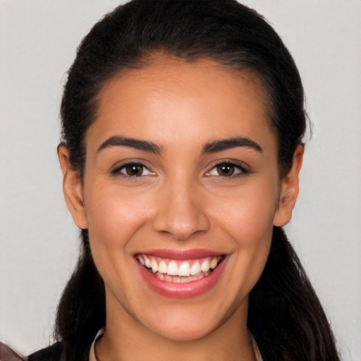 Joyful latino young-adult female with long  black hair and brown eyes