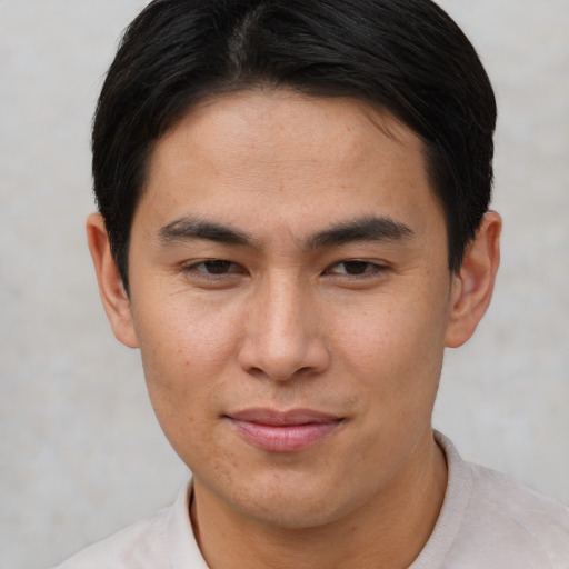 Joyful asian young-adult male with short  brown hair and brown eyes