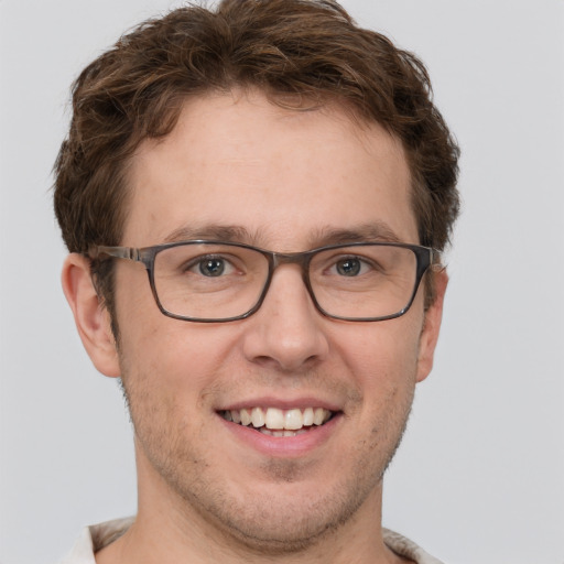 Joyful white adult male with short  brown hair and grey eyes