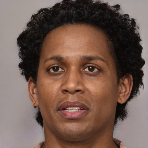 Joyful black adult female with short  brown hair and brown eyes