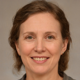 Joyful white adult female with medium  brown hair and brown eyes