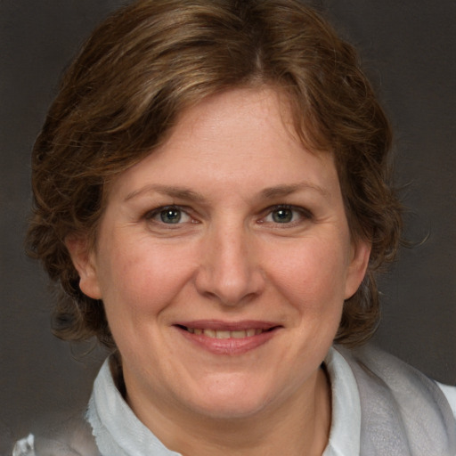 Joyful white adult female with medium  brown hair and blue eyes