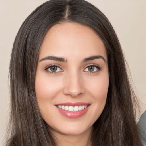 Joyful white young-adult female with long  brown hair and brown eyes