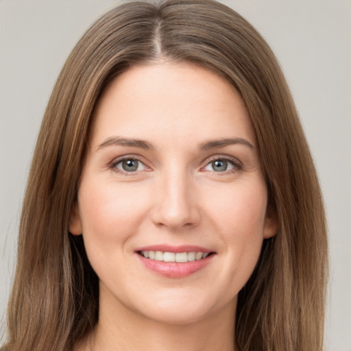 Joyful white young-adult female with long  brown hair and grey eyes