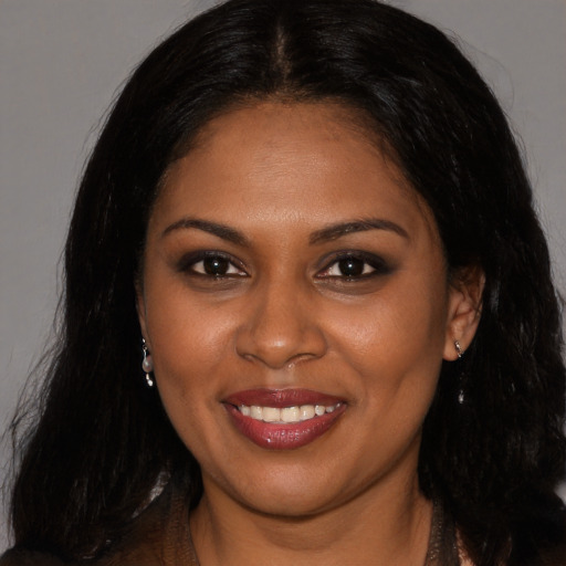Joyful black young-adult female with long  brown hair and brown eyes