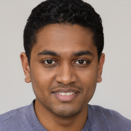 Joyful black young-adult male with short  black hair and brown eyes