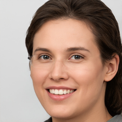 Joyful white young-adult female with medium  brown hair and grey eyes