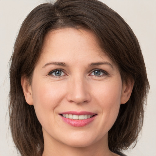 Joyful white adult female with medium  brown hair and brown eyes