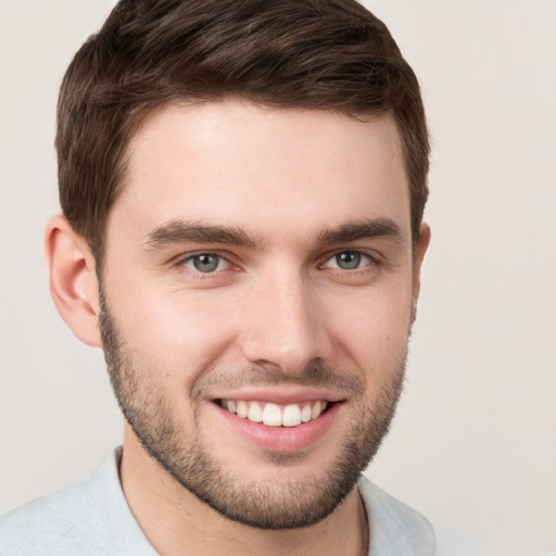 Joyful white young-adult male with short  brown hair and grey eyes