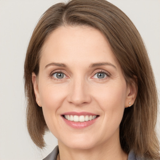 Joyful white young-adult female with medium  brown hair and grey eyes