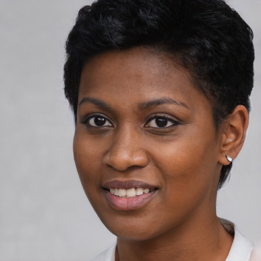 Joyful black young-adult female with short  black hair and brown eyes
