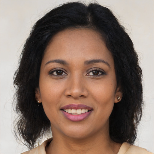 Joyful black young-adult female with long  brown hair and brown eyes