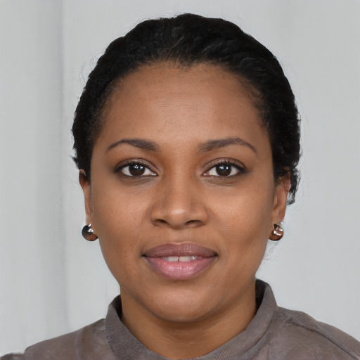 Joyful black young-adult female with short  black hair and brown eyes