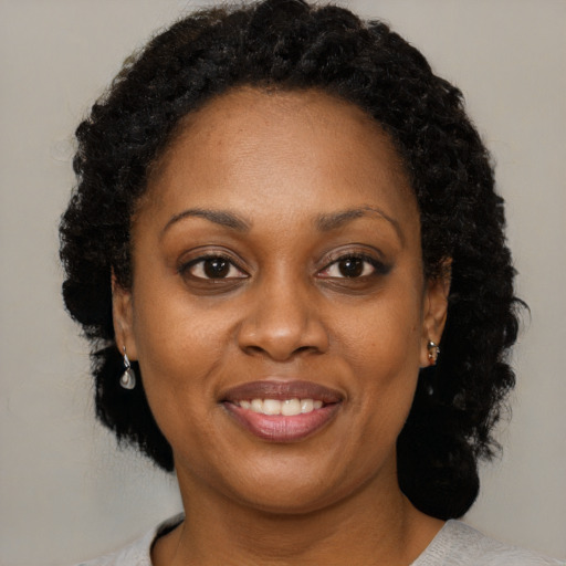 Joyful black adult female with short  black hair and brown eyes