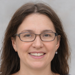 Joyful white adult female with medium  brown hair and grey eyes