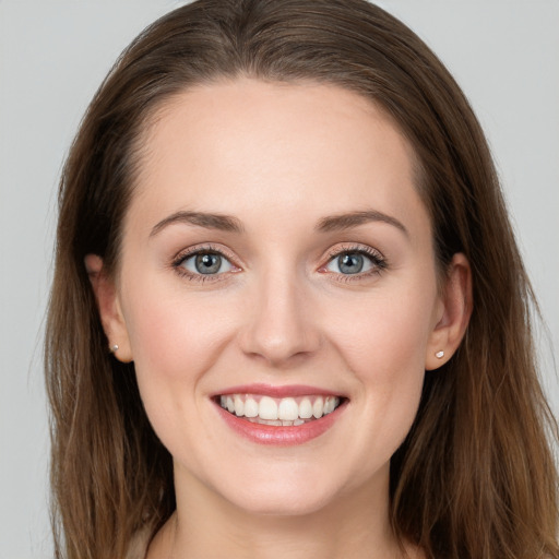 Joyful white young-adult female with long  brown hair and grey eyes