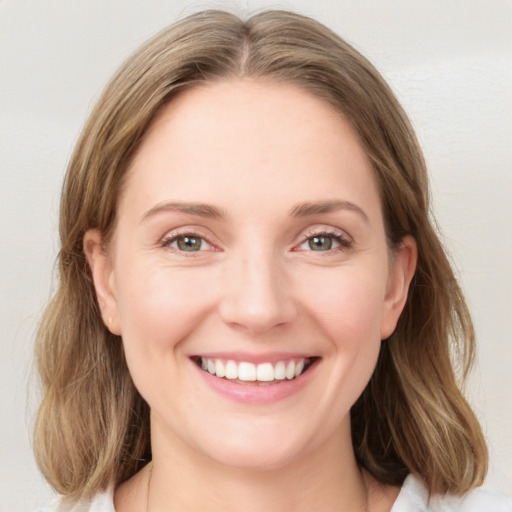 Joyful white young-adult female with medium  brown hair and green eyes