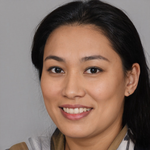 Joyful asian young-adult female with long  brown hair and brown eyes