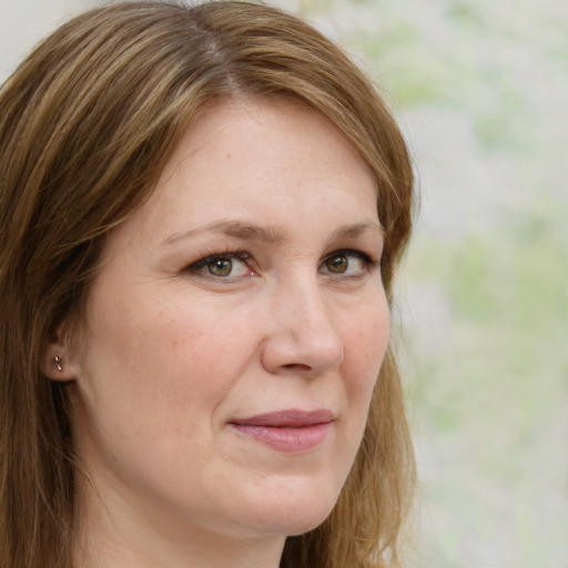 Joyful white adult female with long  brown hair and green eyes