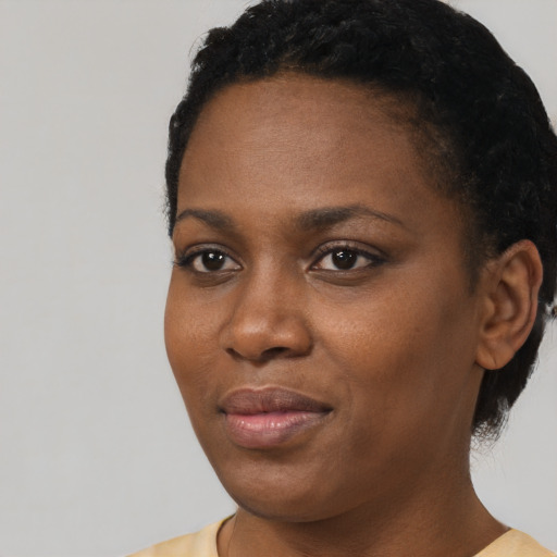 Joyful black young-adult female with short  black hair and brown eyes