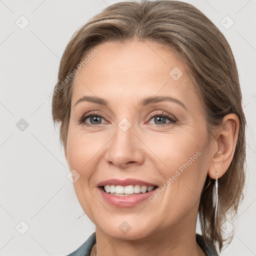 Joyful white adult female with medium  brown hair and grey eyes