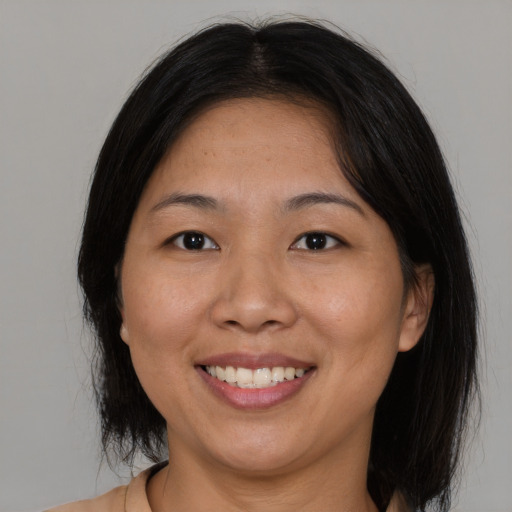 Joyful asian adult female with medium  brown hair and brown eyes
