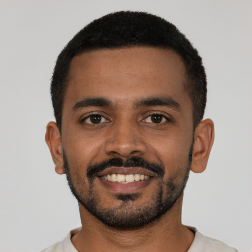 Joyful black young-adult male with short  black hair and brown eyes