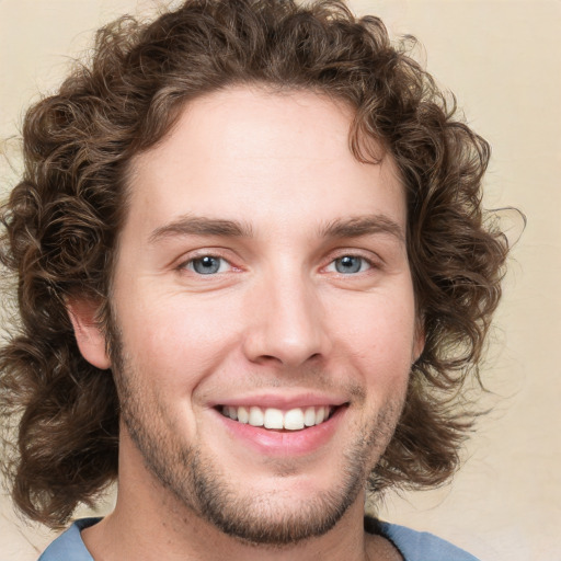 Joyful white young-adult male with medium  brown hair and green eyes