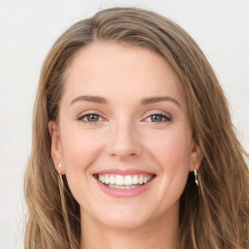 Joyful white young-adult female with long  brown hair and green eyes