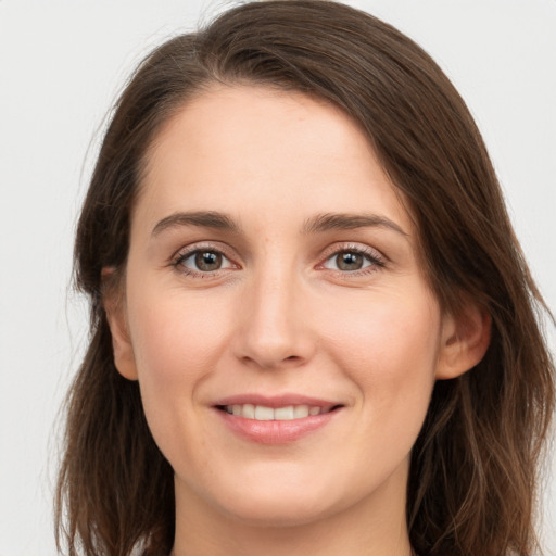 Joyful white young-adult female with long  brown hair and grey eyes