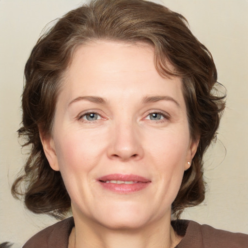 Joyful white adult female with medium  brown hair and grey eyes