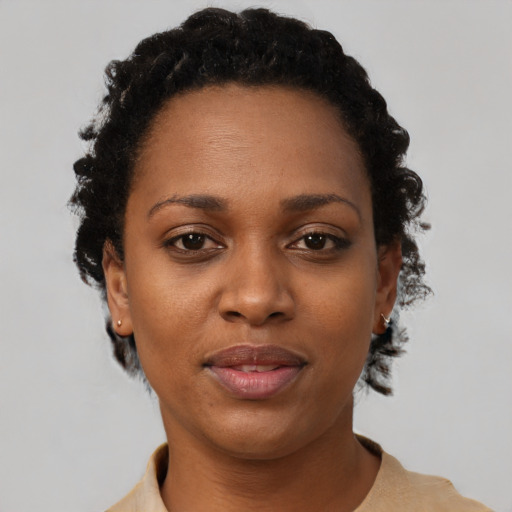 Joyful black young-adult female with short  black hair and brown eyes