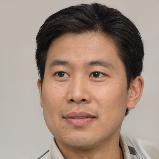 Joyful asian adult male with short  brown hair and brown eyes
