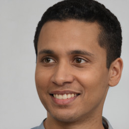 Joyful latino young-adult male with short  black hair and brown eyes