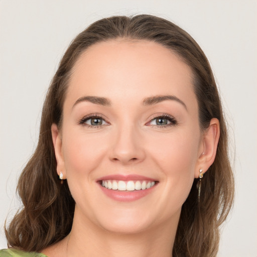 Joyful white young-adult female with long  brown hair and grey eyes