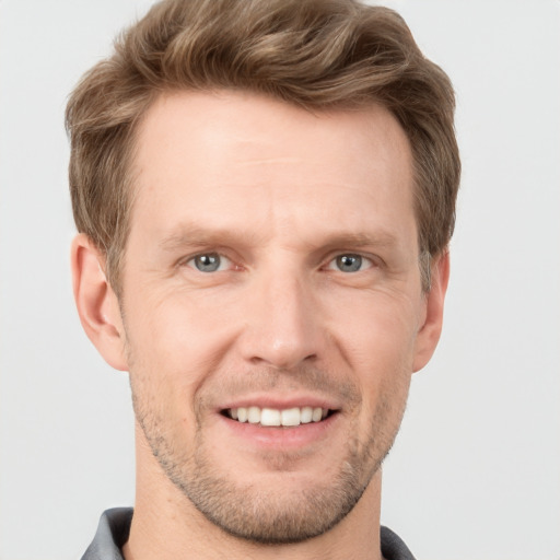 Joyful white adult male with short  brown hair and grey eyes