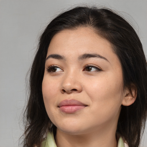 Joyful asian young-adult female with long  brown hair and brown eyes