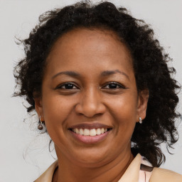 Joyful black adult female with medium  brown hair and brown eyes