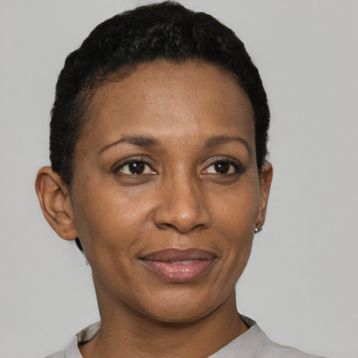 Joyful black adult female with short  black hair and brown eyes