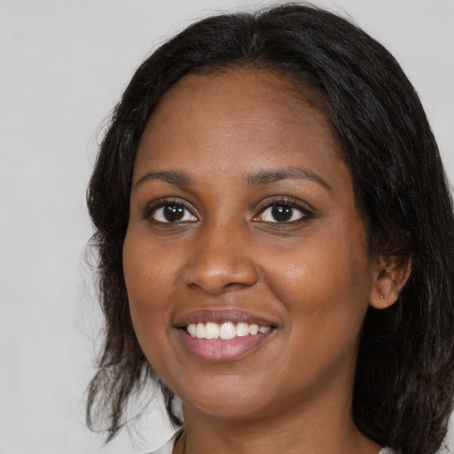 Joyful black young-adult female with medium  brown hair and brown eyes