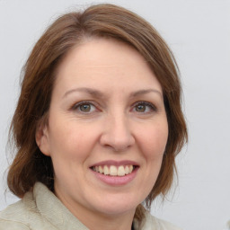 Joyful white adult female with medium  brown hair and grey eyes