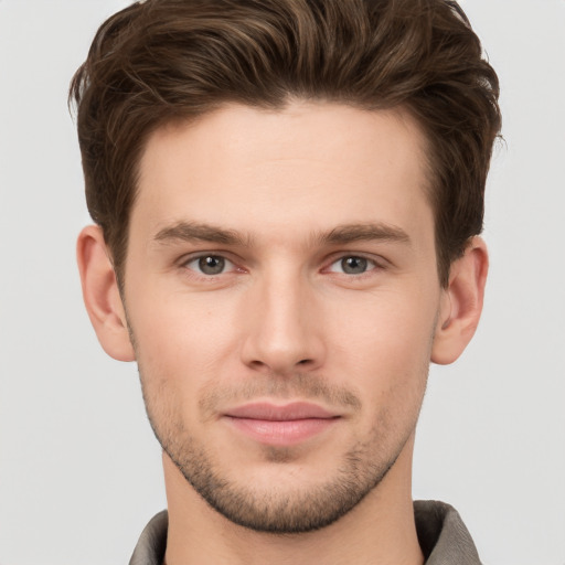 Joyful white young-adult male with short  brown hair and grey eyes