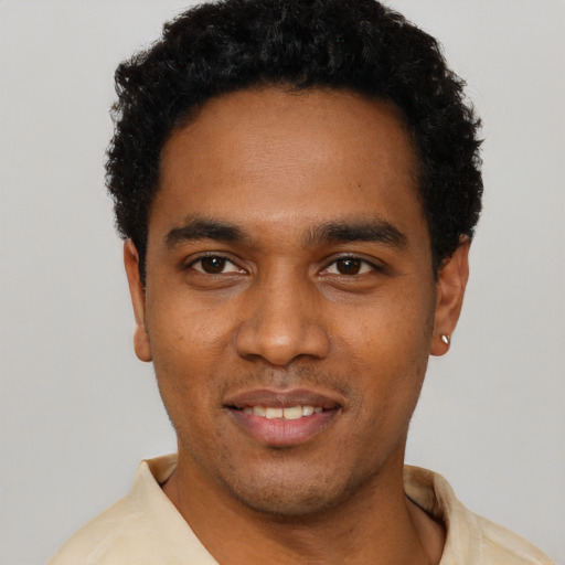 Joyful black young-adult male with short  black hair and brown eyes